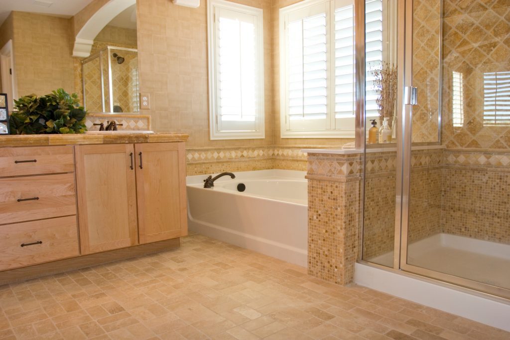 Modern bathroom with separate bathtub and shower and tile wall surrounds and tile flooring.
